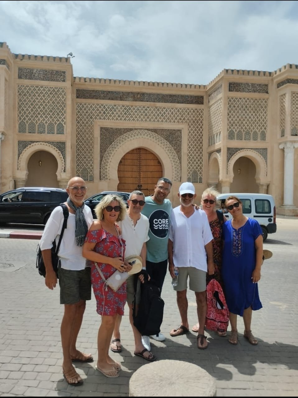 Group of travellers with their driver near a kasbah